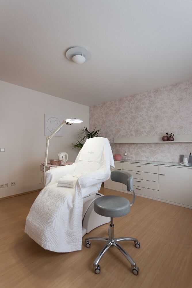 Behandlungsliege mit Lupenlampe und Rollhocker